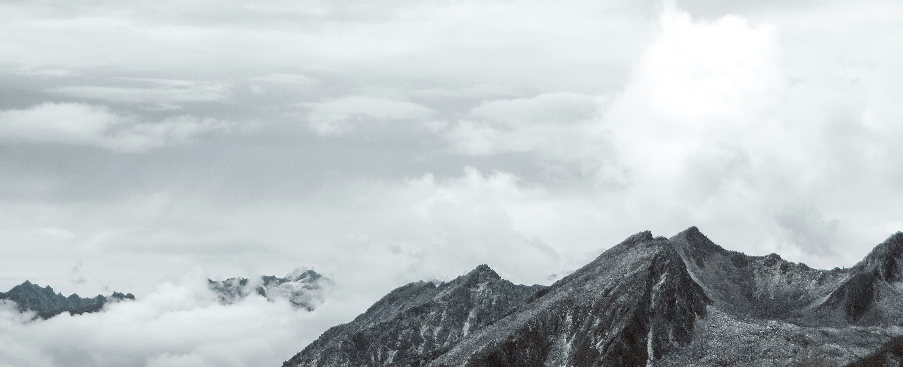 Mountain peaks above clouds, photo by Xingchen Yan